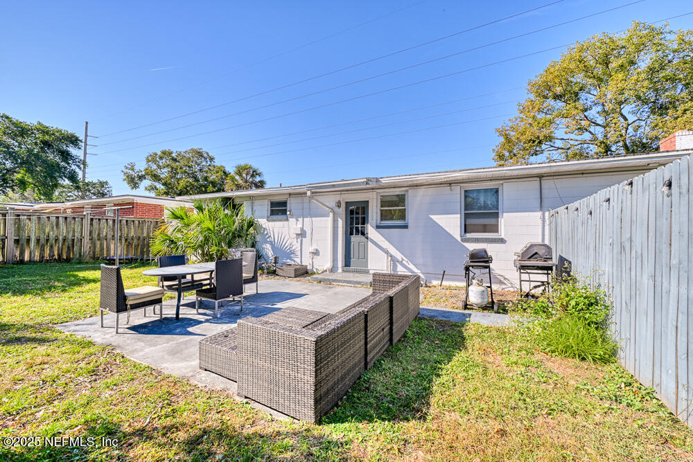 1907 Penman Road Jacksonville Beach, FL 32250 - Photo 16 of 27 a view of a patio with table and chairs with wooden fence