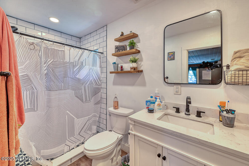 1907 Penman Road Jacksonville Beach, FL 32250 - Photo 26 of 27 a bathroom with a sink a toilet and shower curtain