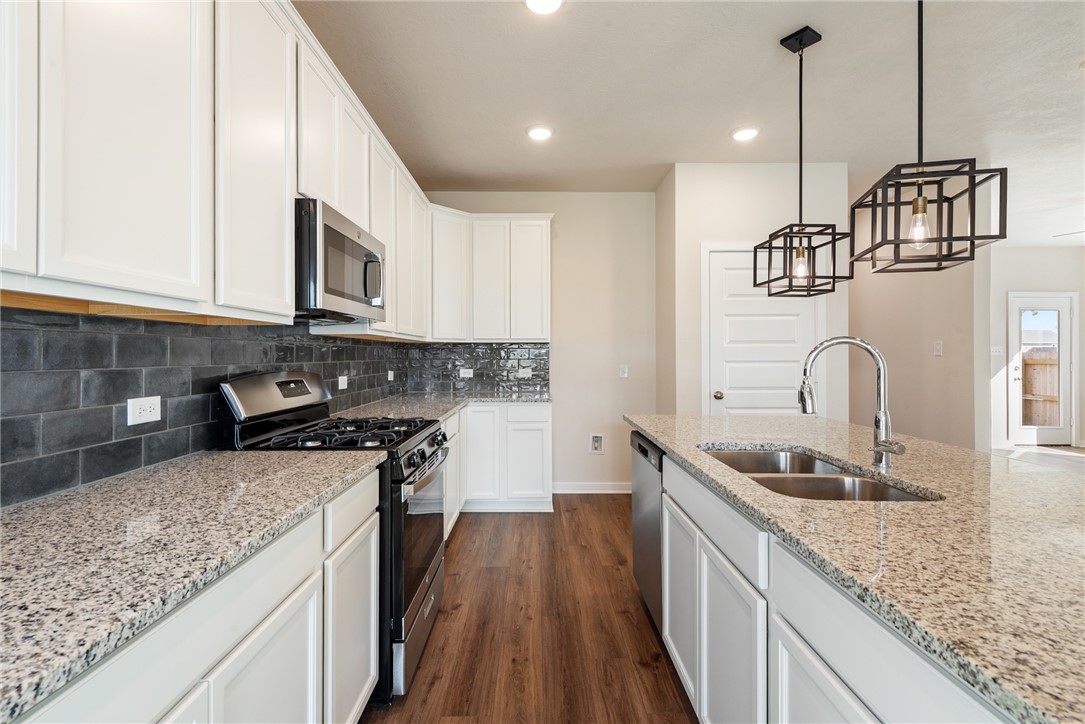 15238 Still Water Mdw Loop Bryan, TX 77845 - Photo 15 of 50 a kitchen with stainless steel appliances granite countertop a sink stove and cabinets