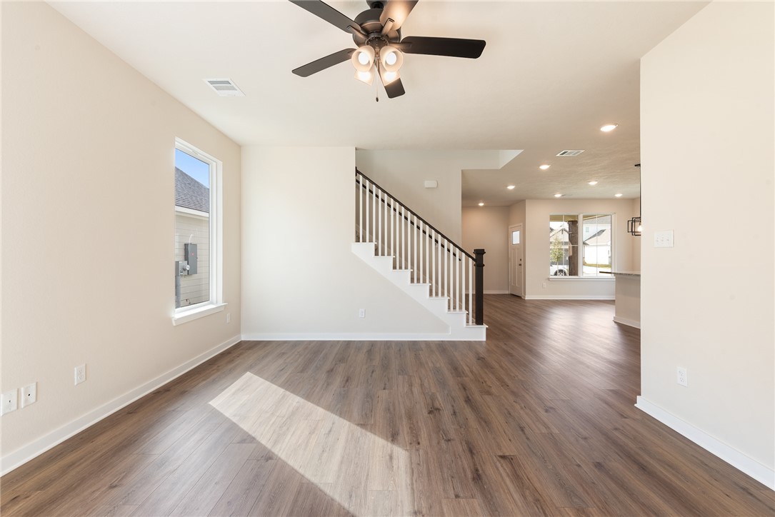 15238 Still Water Mdw Loop Bryan, TX 77845 - Photo 22 of 50 a view of a hallway with wooden floor and a ceiling fan