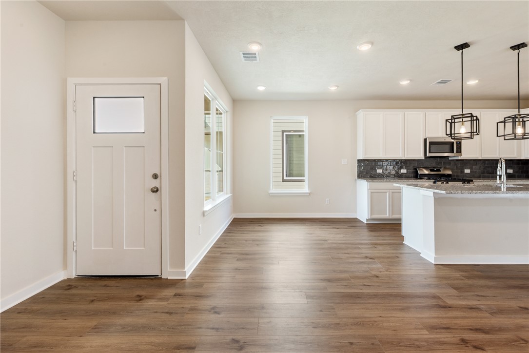 15238 Still Water Mdw Loop Bryan, TX 77845 - Photo 8 of 50 a view of a kitchen with stainless steel appliances granite countertop cabinets and wooden floor