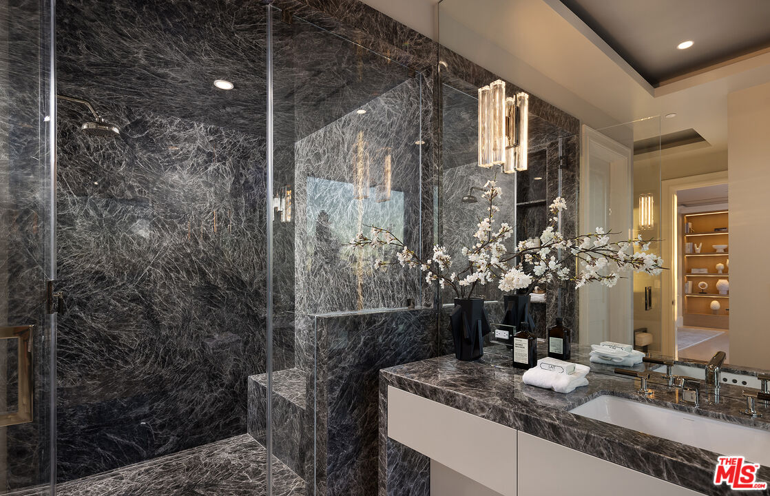 721 North Bonhill Road Los Angeles, CA 90049 - Photo 33 of 64 a bathroom with a granite countertop sink a mirror and a shower