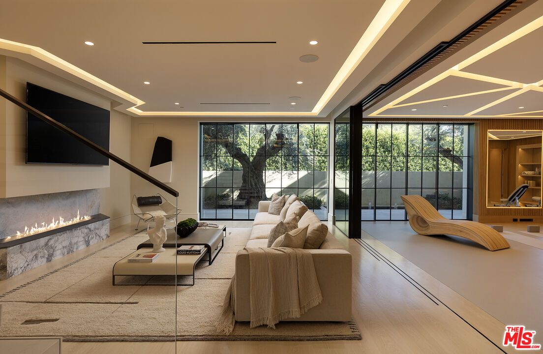 721 North Bonhill Road Los Angeles, CA 90049 - Photo 46 of 64 a living room with furniture floor to ceiling window and a flat screen tv