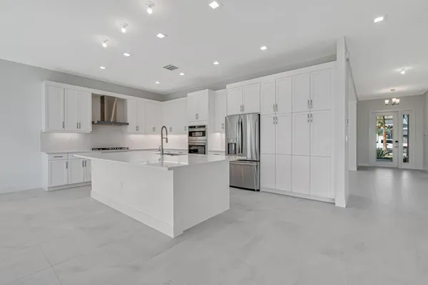 a kitchen with white cabinets and white appliances