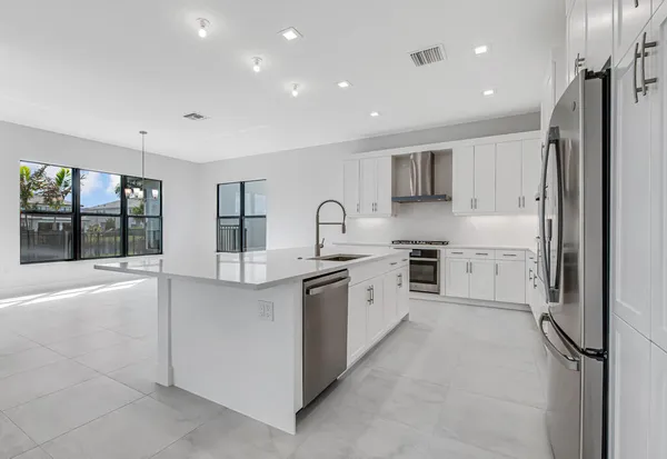 a view of kitchen with refrigerator and window