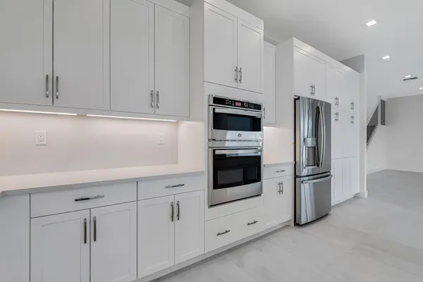 a view of a kitchen with stainless steel appliances granite countertop a sink and cabinets