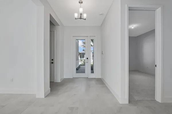 a living room with stainless steel appliances furniture a refrigerator and white cabinets