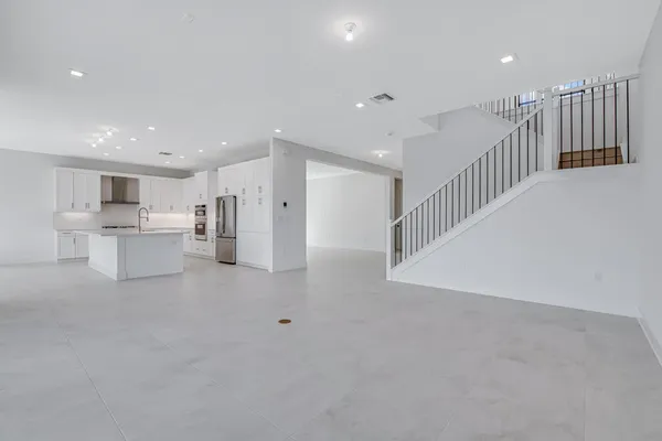 a large white kitchen with granite countertop a large window