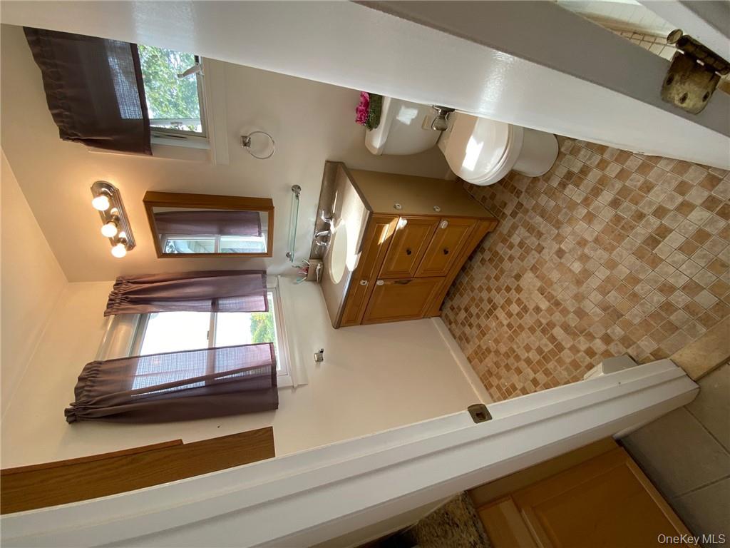 49 Croton Point Avenue, Unit C Croton-on-Hudson, NY 10520 - Photo 16 of 17 a bathroom with a sink toilet and mirror