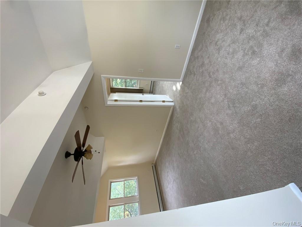 49 Croton Point Avenue, Unit C Croton-on-Hudson, NY 10520 - Photo 17 of 17 an empty room with a ceiling fan and windows