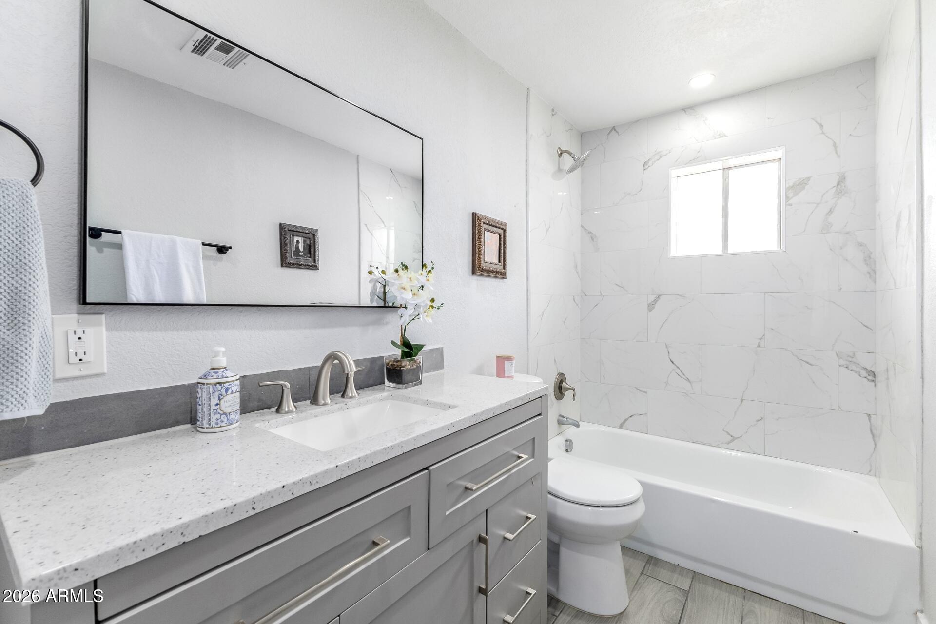 17428 North 20th Street Phoenix, AZ 85022 - Photo 15 of 24 a bathroom with a granite countertop sink a toilet a mirror and bathtub