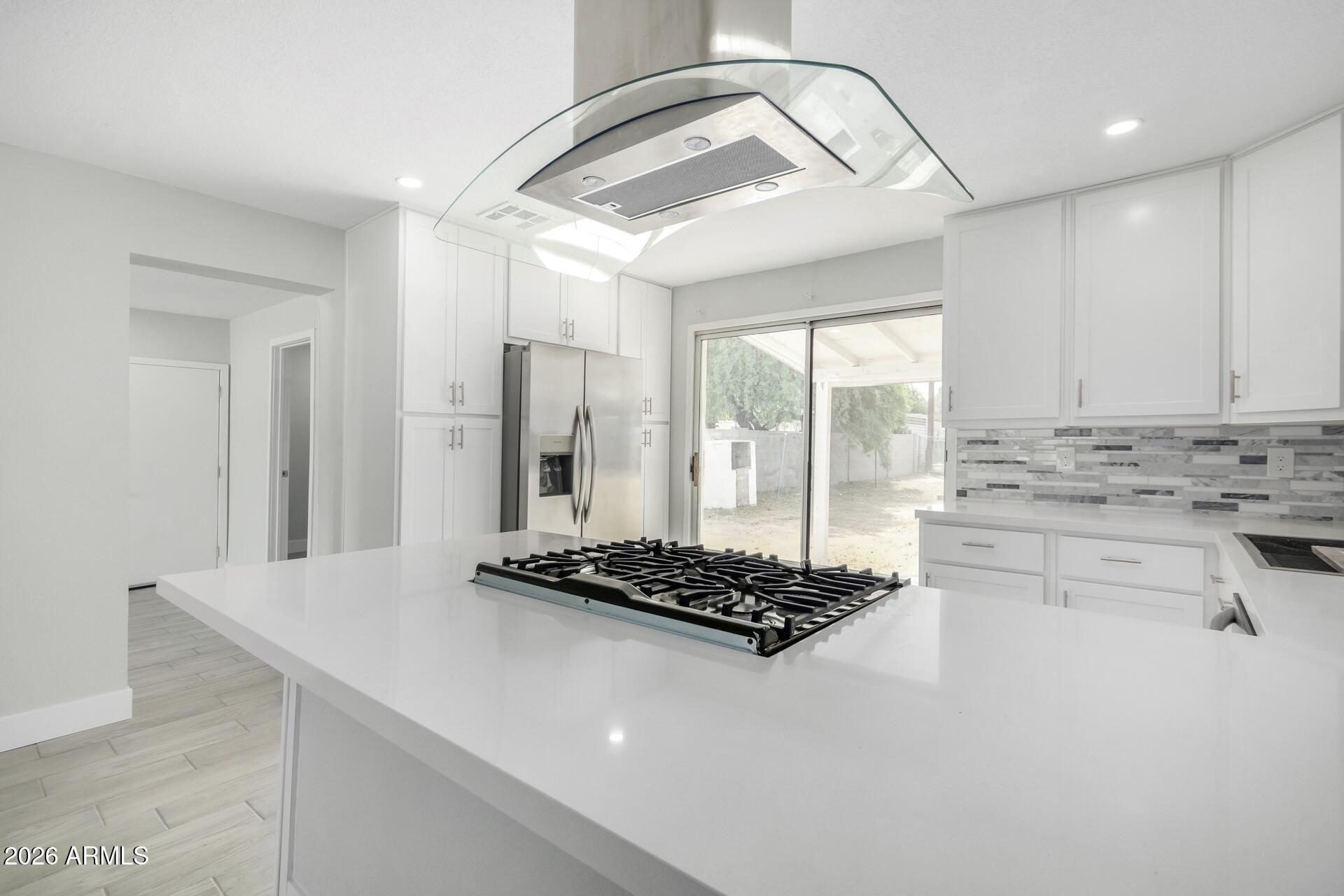17428 North 20th Street Phoenix, AZ 85022 - Photo 5 of 24 a kitchen with stainless steel appliances kitchen island a stove a refrigerator and white cabinets