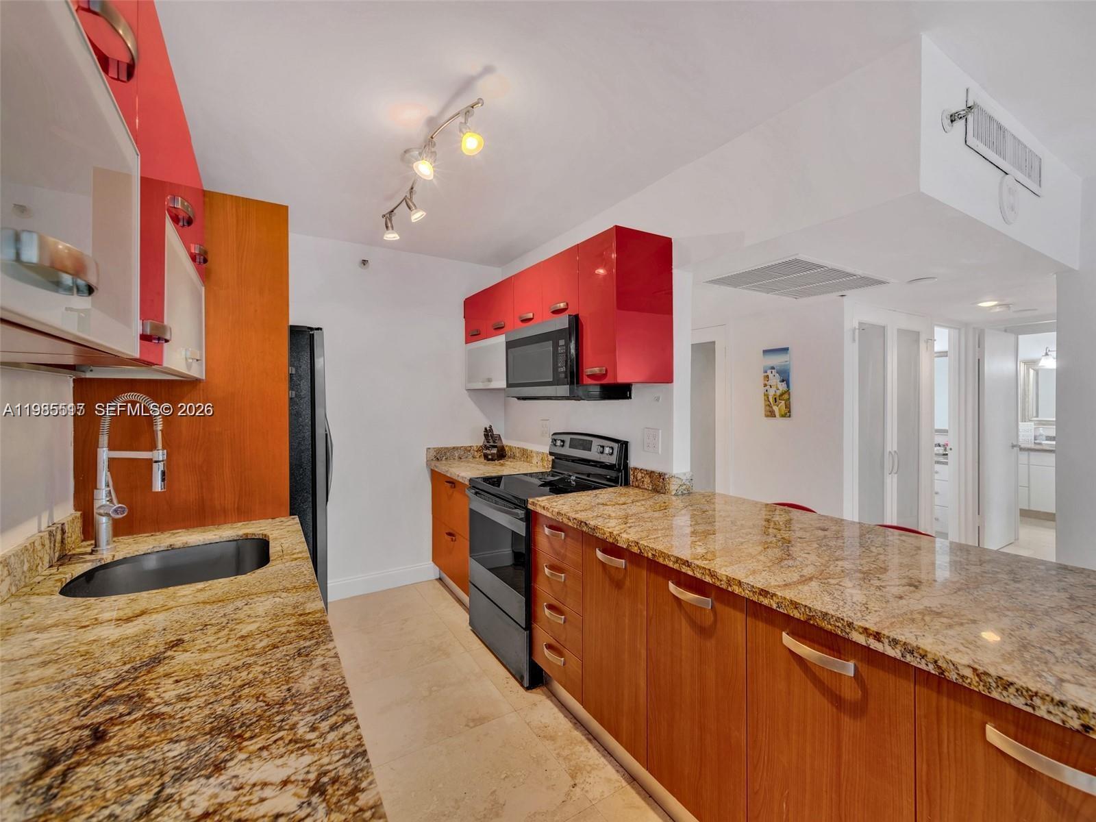100 Lincoln Road, Unit 308 Miami Beach, FL 33139 - Photo 5 of 11 a kitchen with stainless steel appliances granite countertop a sink stove and refrigerator