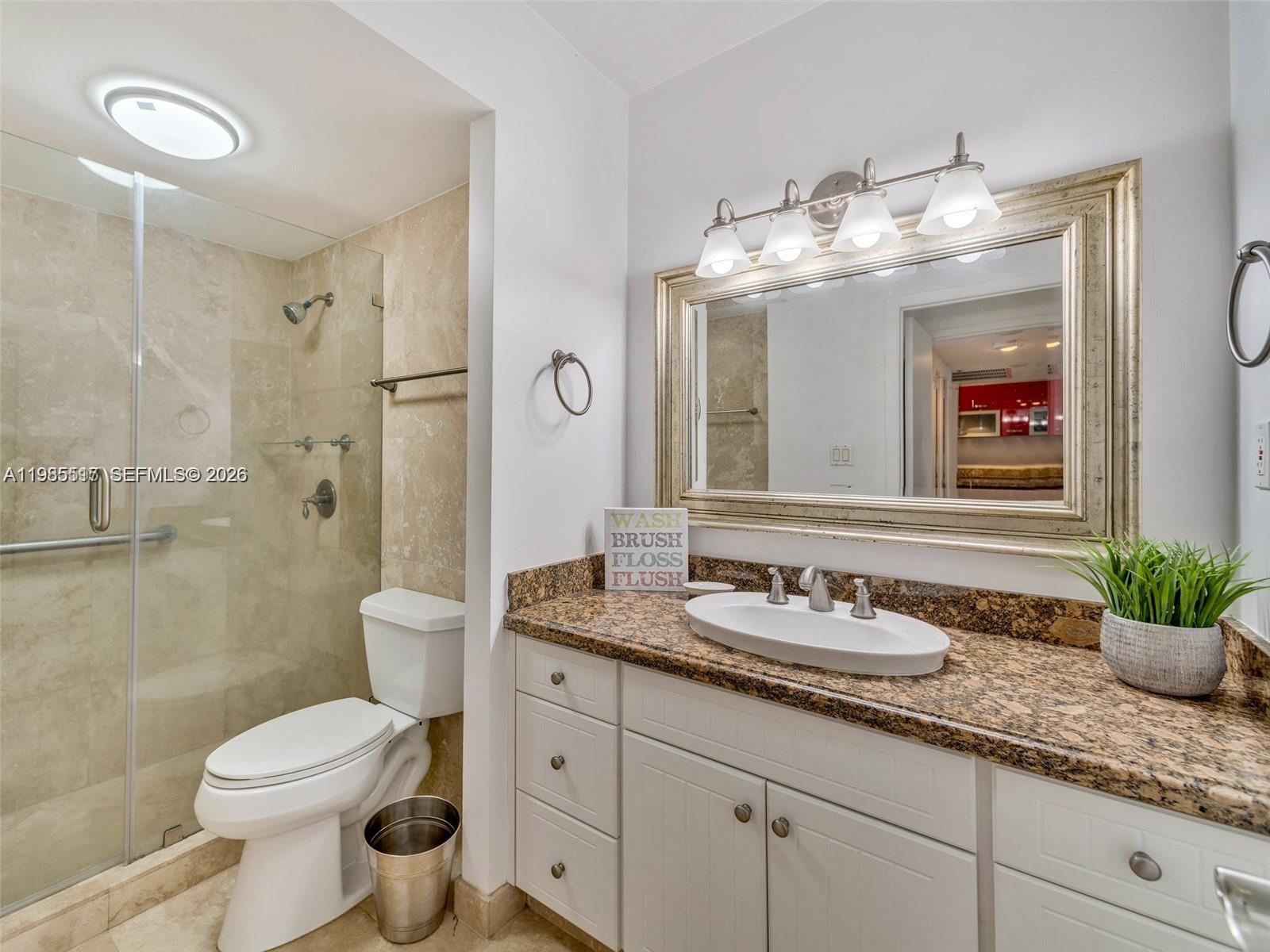 100 Lincoln Road, Unit 308 Miami Beach, FL 33139 - Photo 8 of 11 a bathroom with a granite countertop sink toilet a large mirror a shower and a mirror