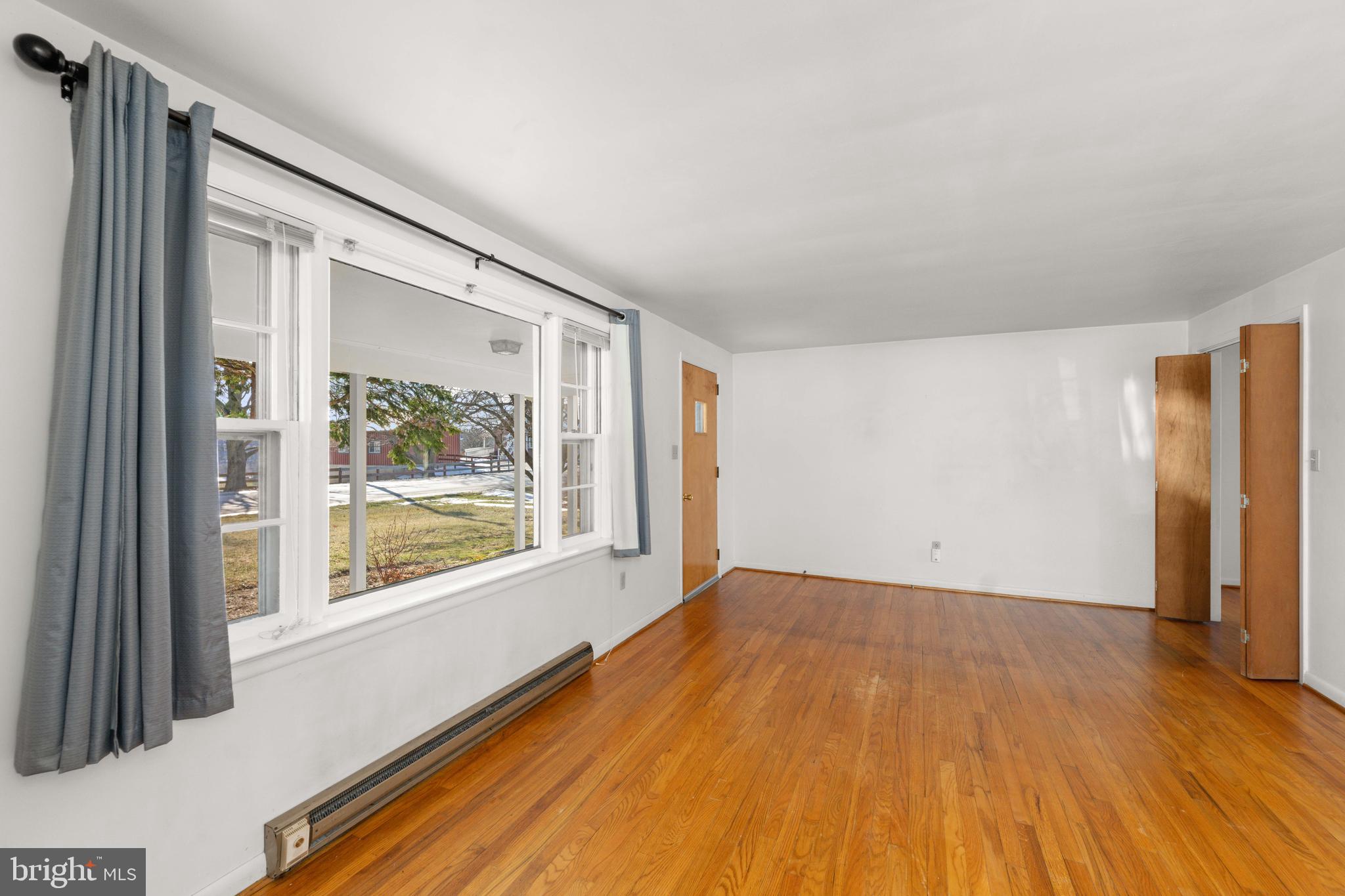 561 Georgetown Road Ronks, PA 17572 - Photo 8 of 34 a view of an empty room with a window and wooden floor