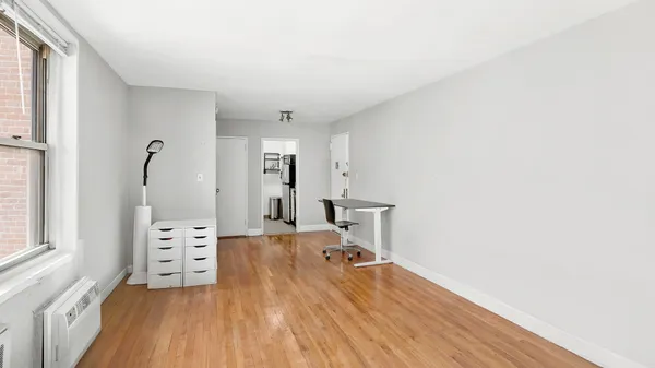 a view of a bedroom with furniture and wooden floor