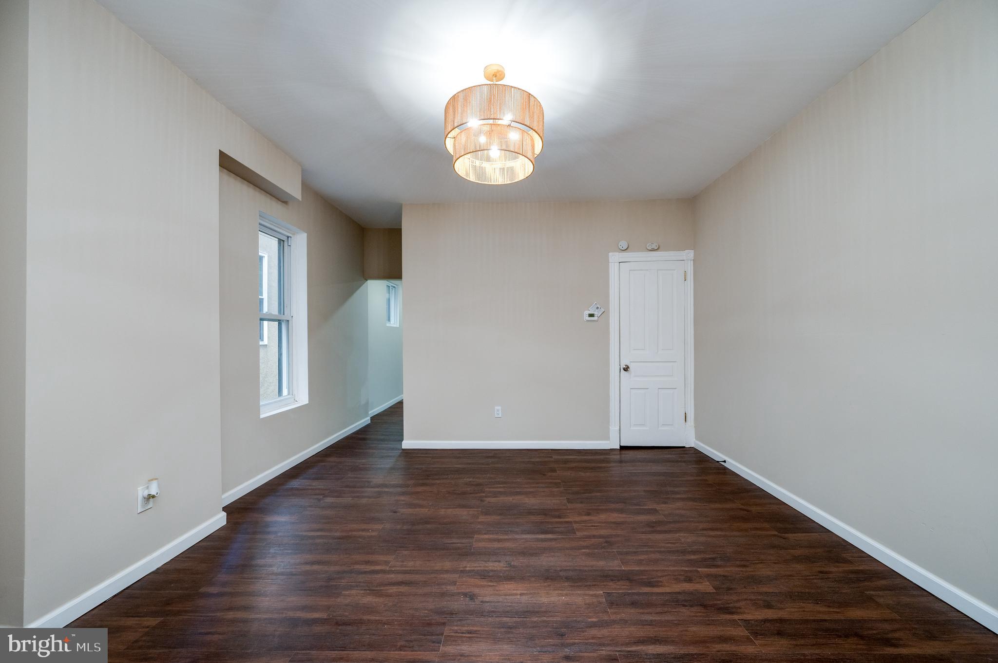 137 Elm Street Reading, PA 19601 - Photo 12 of 49 a view of an empty room with wooden floor and a window