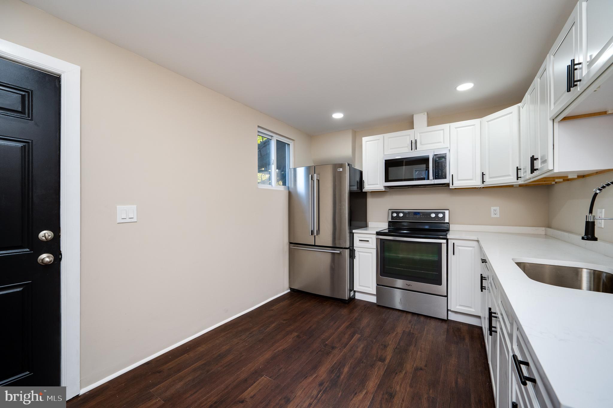 137 Elm Street Reading, PA 19601 - Photo 19 of 49 a kitchen with a sink a microwave a refrigerator and cabinets