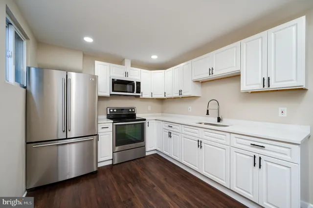 a kitchen with stainless steel appliances granite countertop grey cabinets a stove a sink and dishwasher