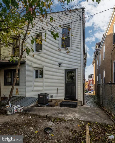 a view of a backyard with large trees and a barn