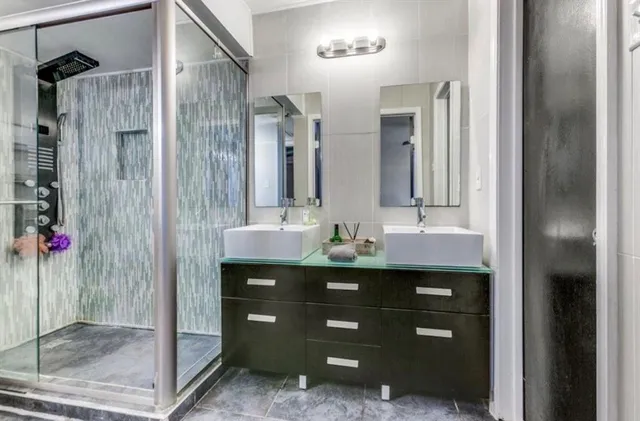 a bathroom with a shower sink vanity and mirror