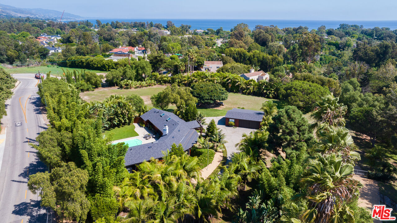 an aerial view of a house with a yard and lake view