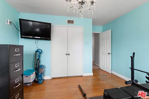 a view of a livingroom with wooden floor and a flat screen tv