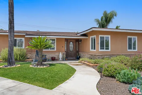 a front view of a house with a garden and yard
