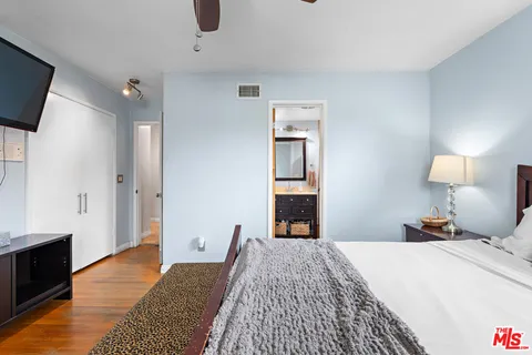 a bedroom with a bed and wooden floor