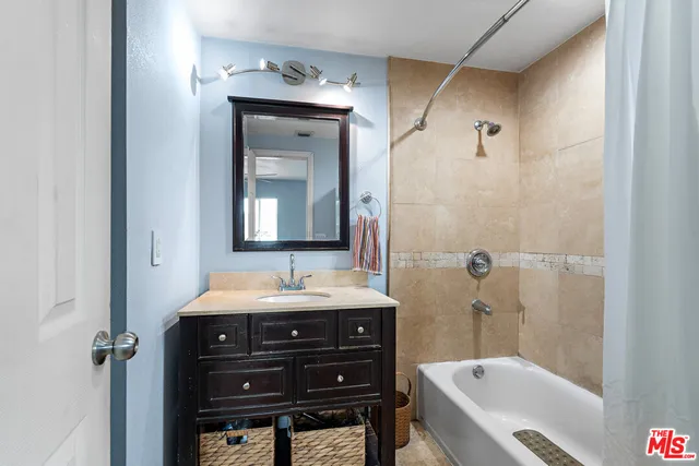 a bathroom with a tub sink and mirror