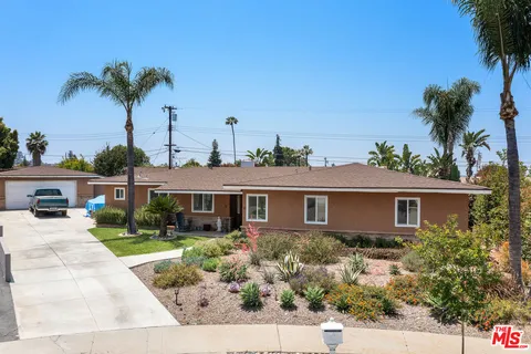 front view of a house with a yard and potted plants
