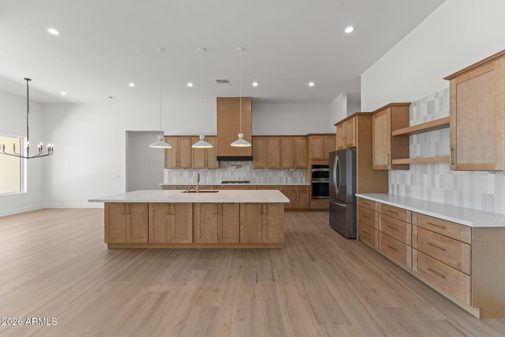 2855 Percheron Road Wickenburg, AZ 85390 - Photo 19 of 58 a large kitchen with stainless steel appliances granite countertop a large counter top a sink dishwasher a refrigerator and white cabinets with wooden floor