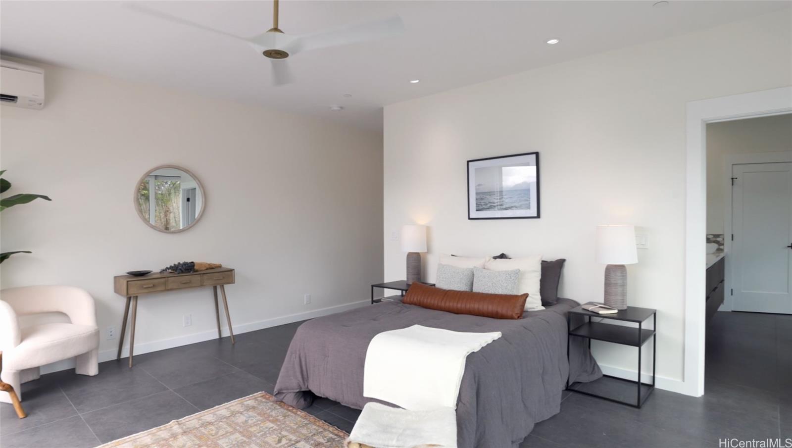 44-652 Kaneohe Bay Drive, Unit A Kaneohe, HI 96744 - Photo 17 of 25 a bedroom with a bed a mirror and chair