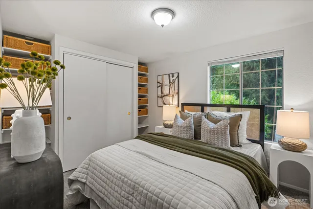a bedroom with a bed lamp and a large window