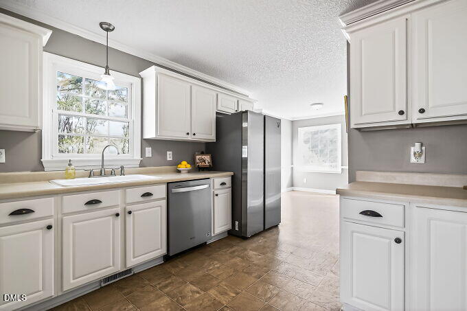 6733 Oviedo Drive Raleigh, NC 27603 - Photo 11 of 33 a kitchen with granite countertop white cabinets white appliances a sink and a window