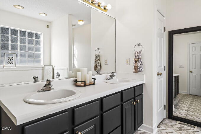 6733 Oviedo Drive Raleigh, NC 27603 - Photo 18 of 33 a bathroom with a sink and a mirror
