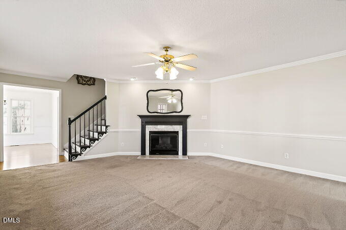 6733 Oviedo Drive Raleigh, NC 27603 - Photo 7 of 33 a view of an empty room with a fireplace and a chandelier