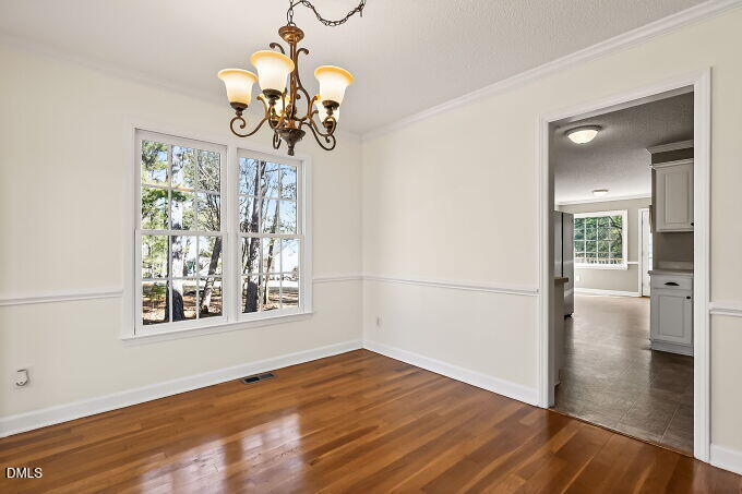 6733 Oviedo Drive Raleigh, NC 27603 - Photo 10 of 33 a view of a room with wooden floor chandelier and glass door