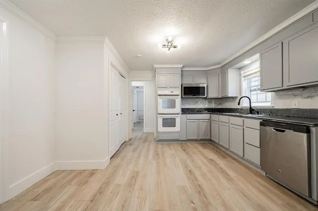 a kitchen with granite countertop white cabinets and white appliances