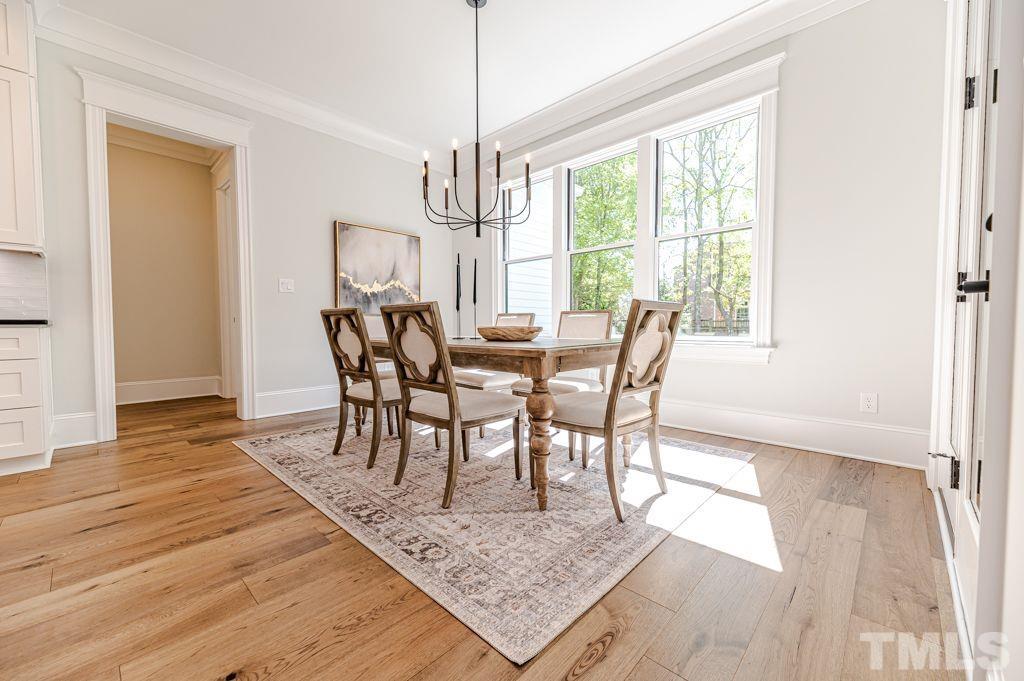 10822 Grand Journey Avenue Raleigh, NC 27614 - Photo 12 of 41 a view of a dining room with furniture window and wooden floor