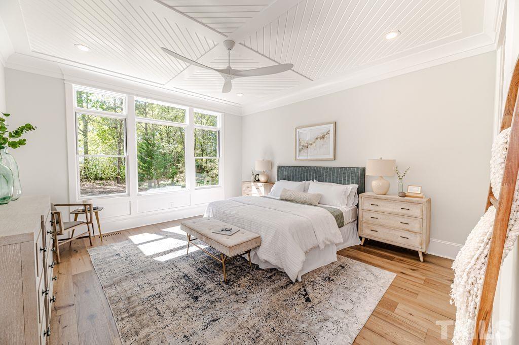 10822 Grand Journey Avenue Raleigh, NC 27614 - Photo 18 of 41 a spacious bedroom with a bed and wooden floor