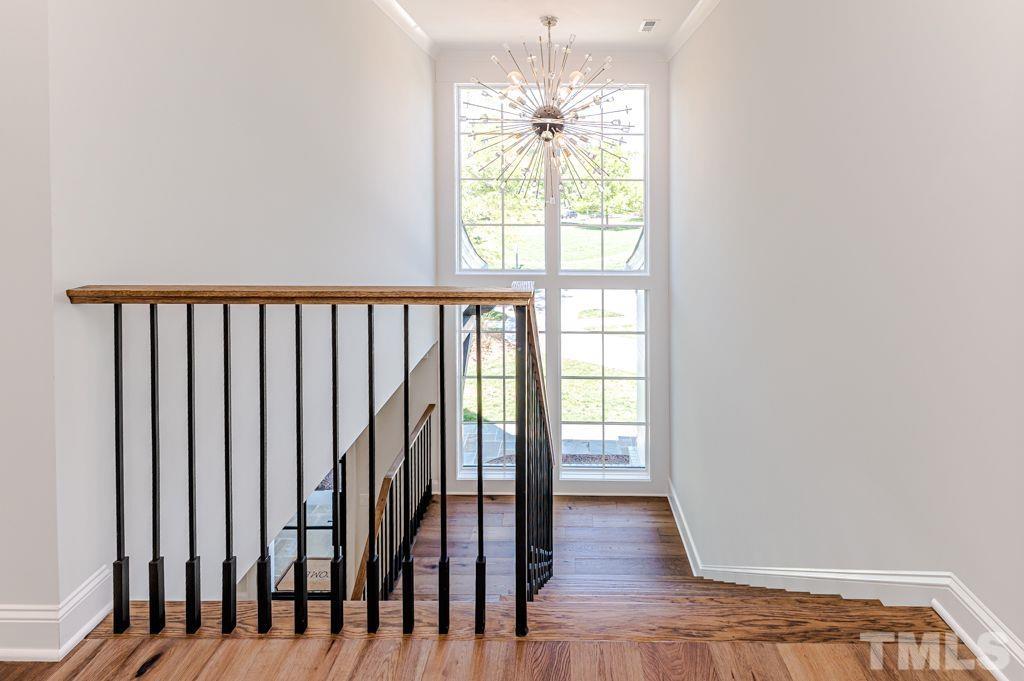 10822 Grand Journey Avenue Raleigh, NC 27614 - Photo 24 of 41 a view of a hallway with wooden floor and chandelier