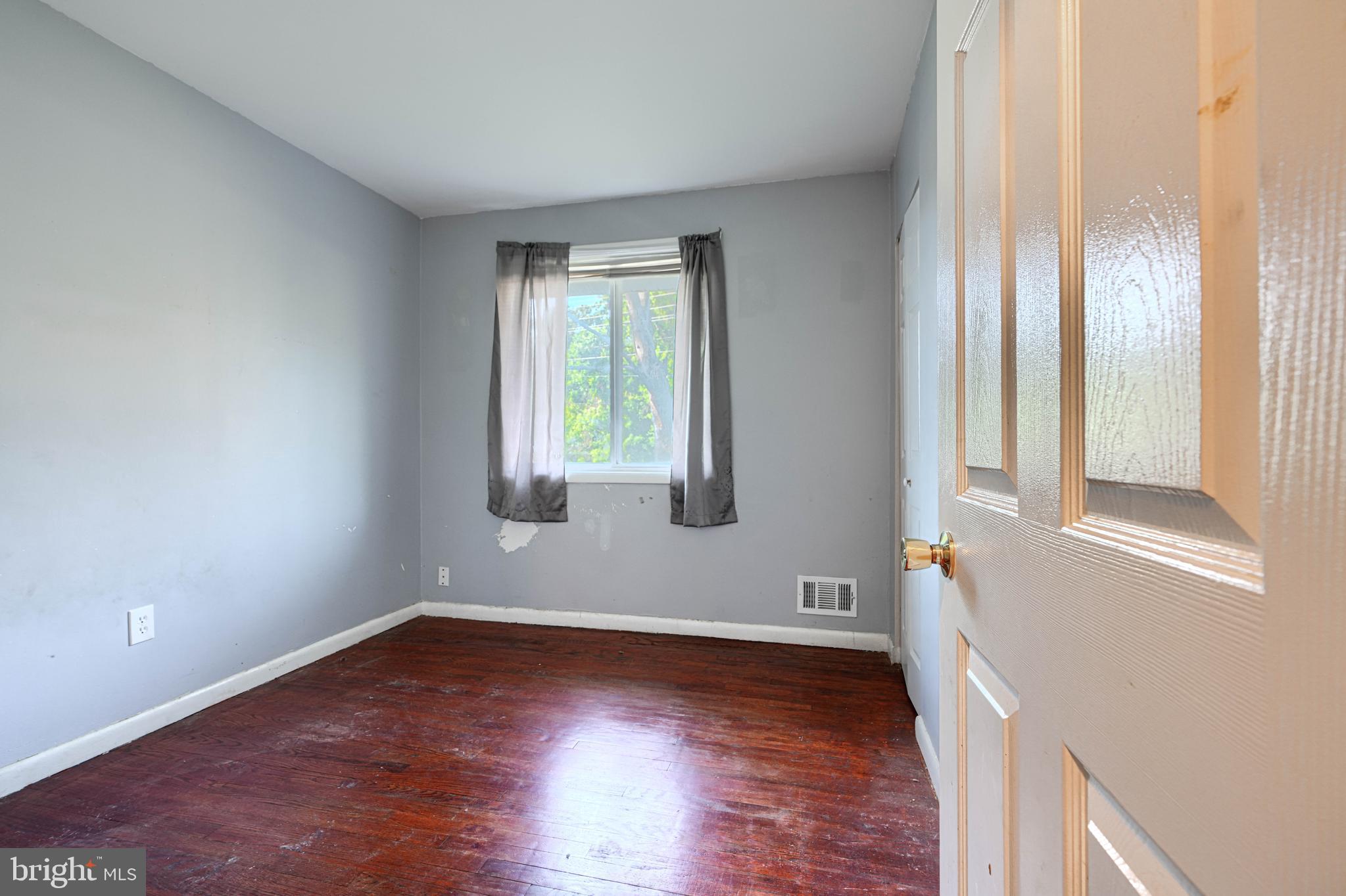 9706 Liberty Road Randallstown, MD 21133 - Photo 22 of 43 a view of an empty room with wooden floor and a window