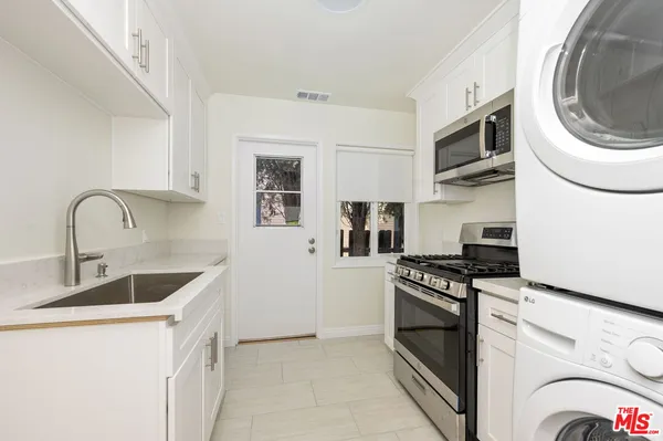 a kitchen with stainless steel appliances granite countertop a sink and a stove top oven