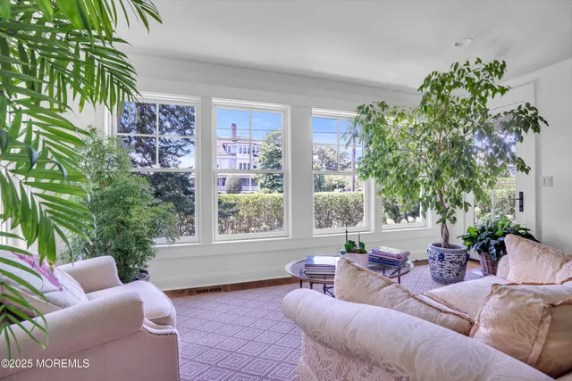 a living room with furniture a flat screen tv and a large window