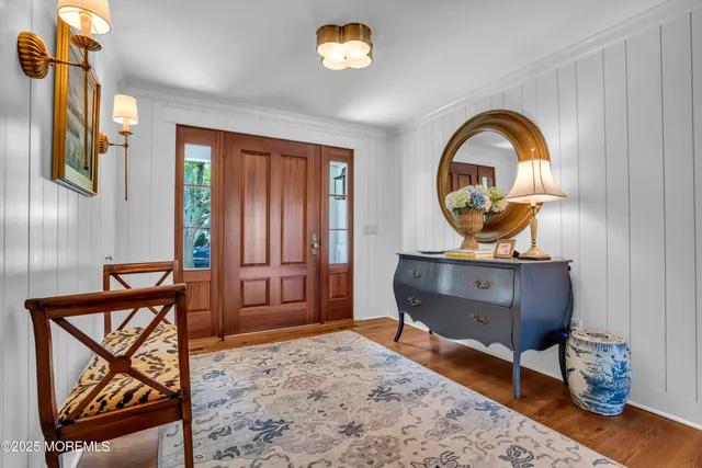 a living room with furniture a wooden floor and a floor to ceiling window