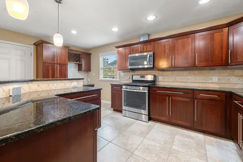a kitchen with stainless steel appliances granite countertop a sink stove and microwave