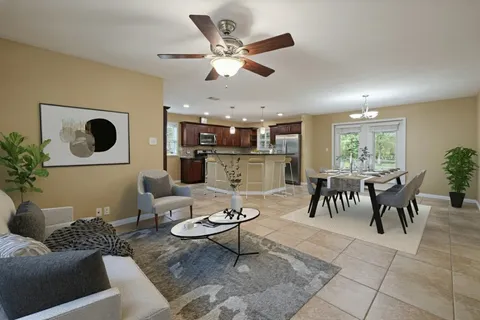 a living room with furniture and view of kitchen