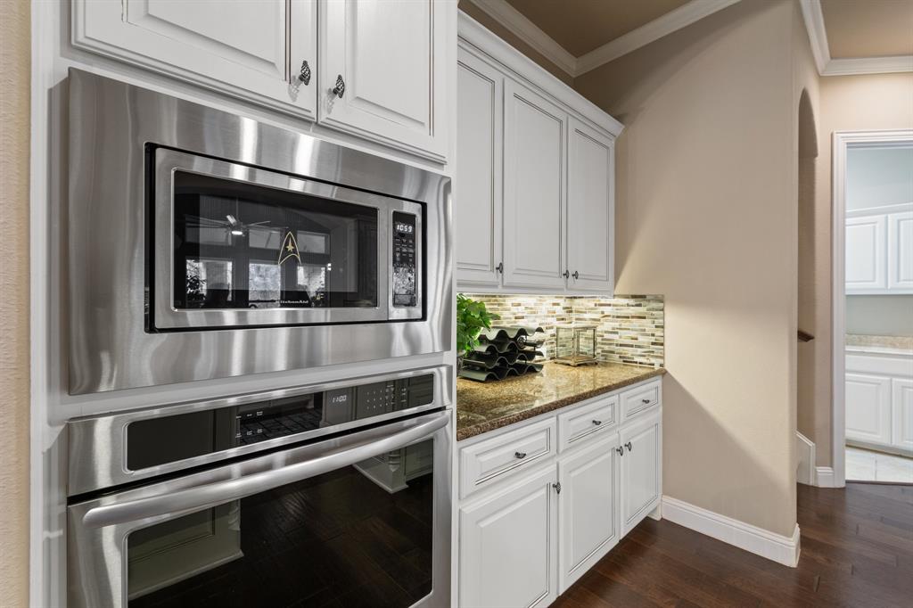 4711 Taylor Lane Grapevine, TX 76051 - Photo 11 of 31 a kitchen with white cabinets and stainless steel appliances