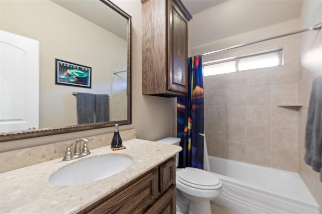 4711 Taylor Lane Grapevine, TX 76051 - Photo 26 of 31 a bathroom with a granite countertop sink toilet and a mirror